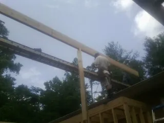 Carpenter setting a ridge beam over a new addition frame — Ice Dam Removal by Roofing Brothers in Tonawanda