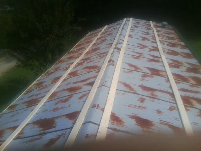 Rusted metal roof panels with new wood purlins before replacement — Storm Damage Roof Repair in Tonawanda by Roofing Brothers