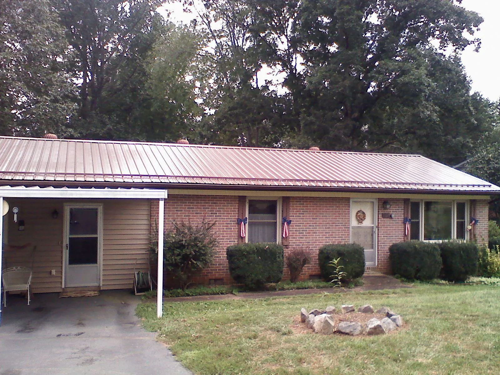 Bronze metal roof and carport on a brick ranch home — Roof Repair work by our crew in Tonawanda